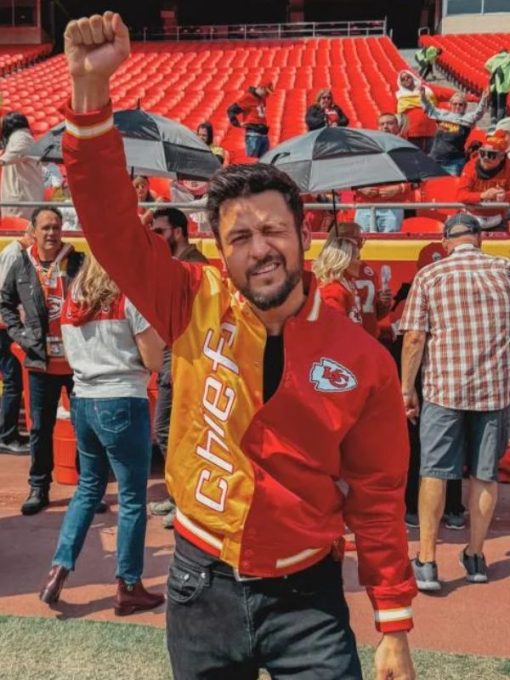 Man in Chiefs jacket celebrating at a sports event with fans in the background