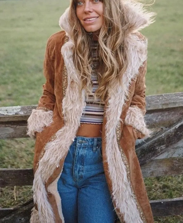 Woman wearing a brown coat with fur trim in an outdoor setting