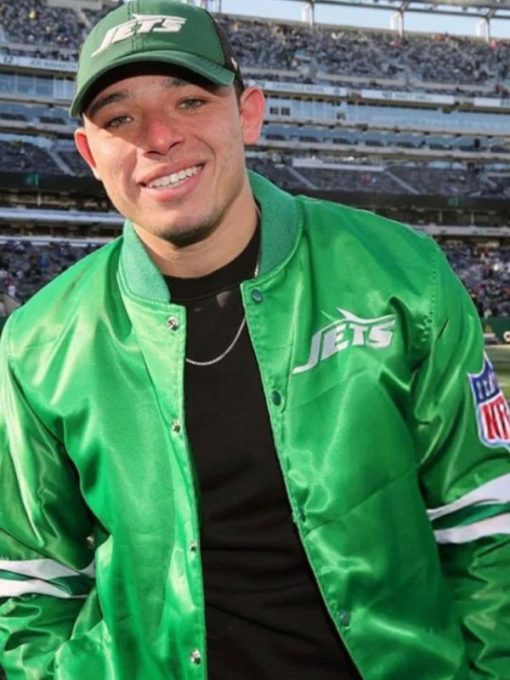 Person wearing a green sports team jacket and cap in a stadium setting