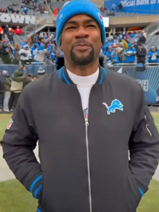 Person wearing a Detroit Lions jacket and blue beanie at a sports event
