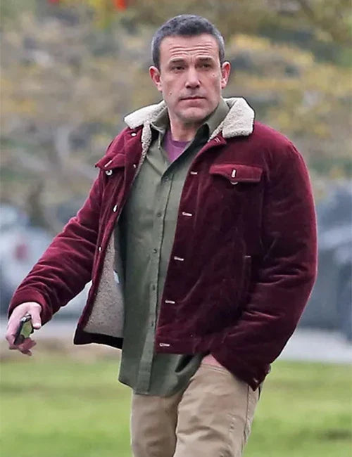 Man wearing a maroon jacket with a fur-lined hood outdoors