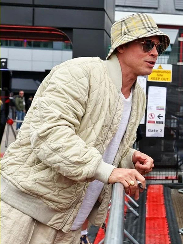 Person wearing a beige quilted jacket and hat, standing near an airport gate.
