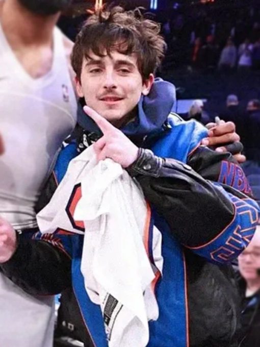 Person wearing a blue jacket with a white shirt underneath, pointing upwards.