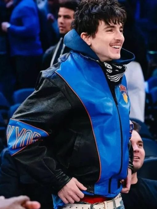Person wearing a blue and black jacket with visible branding in an indoor setting