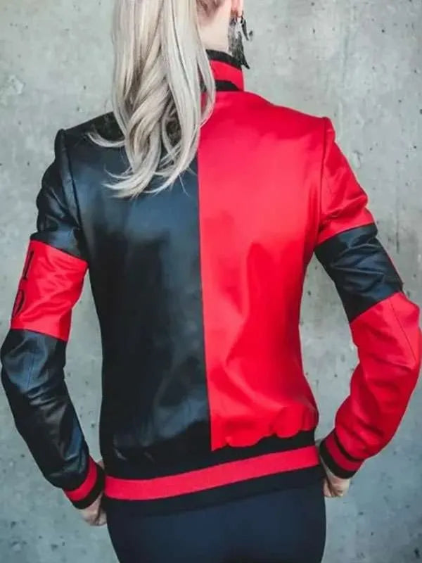 Person wearing a black and red jacket against a concrete wall.